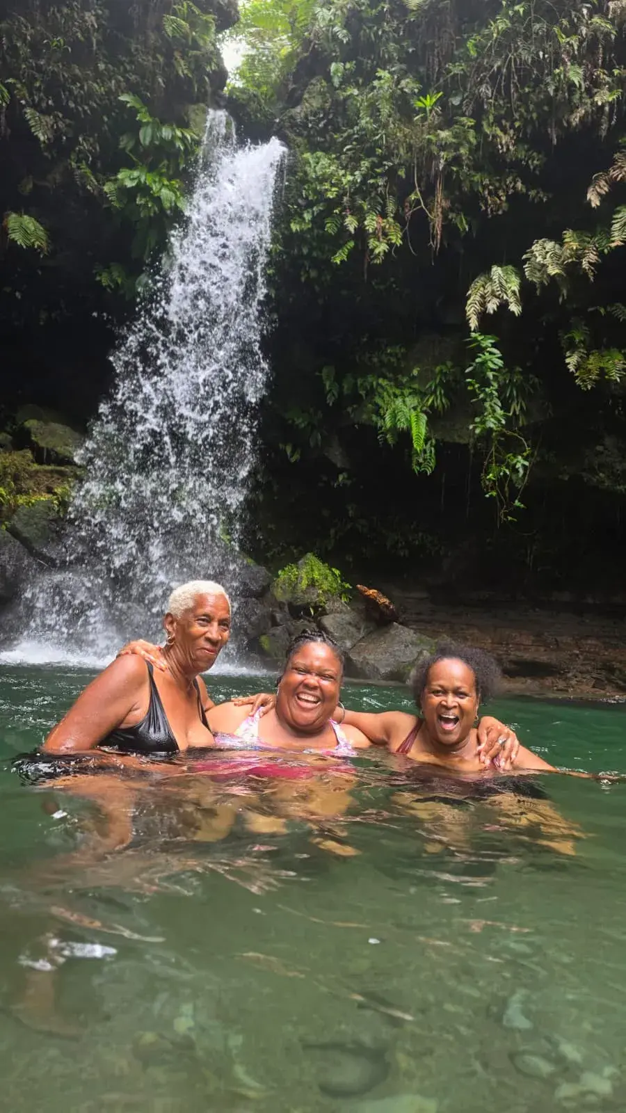 Guests enjoying a rainforest waterfall pool on the Waterfall Hopping adventure