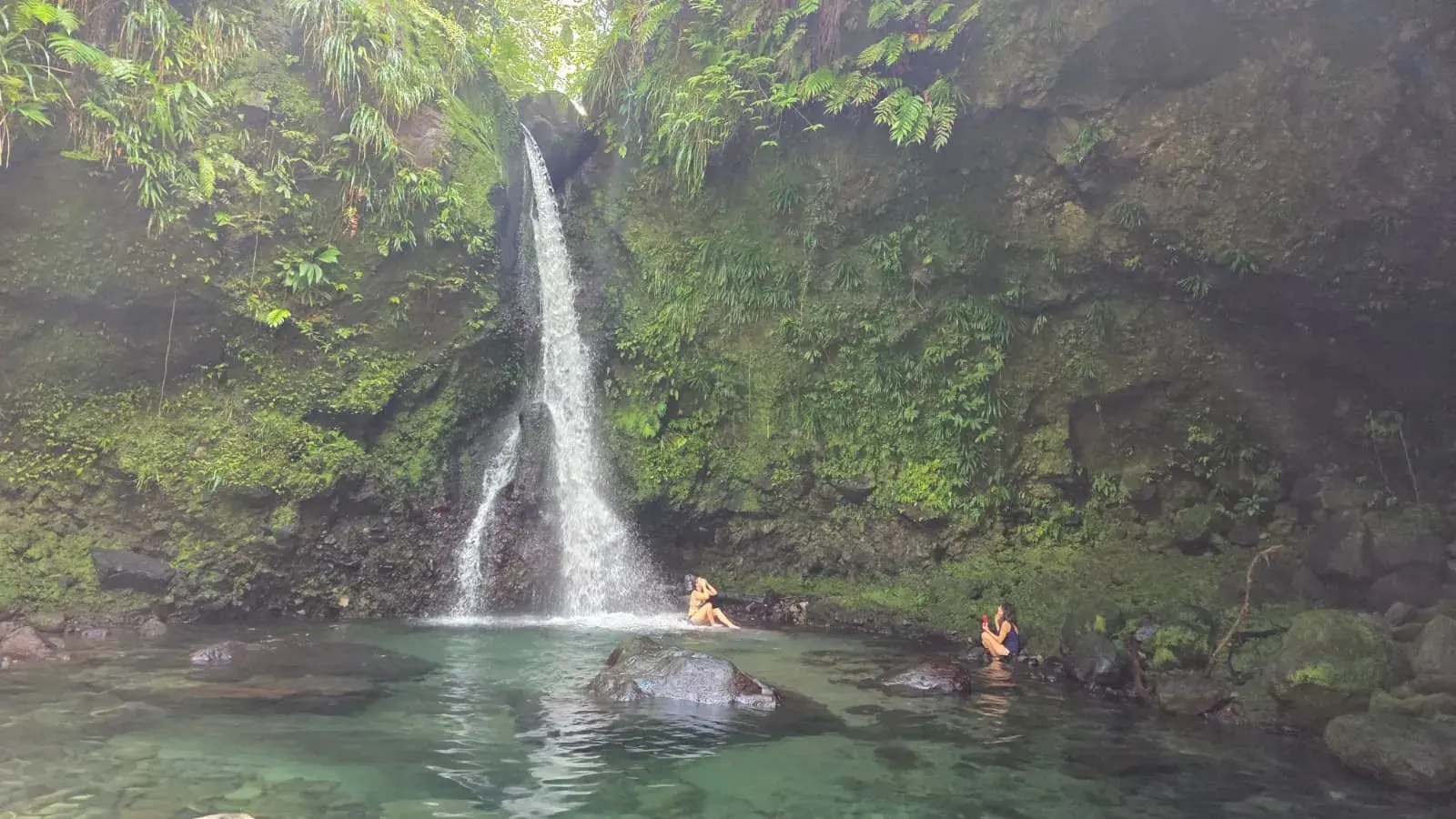 Waterfall with swimmers in the plunge pool