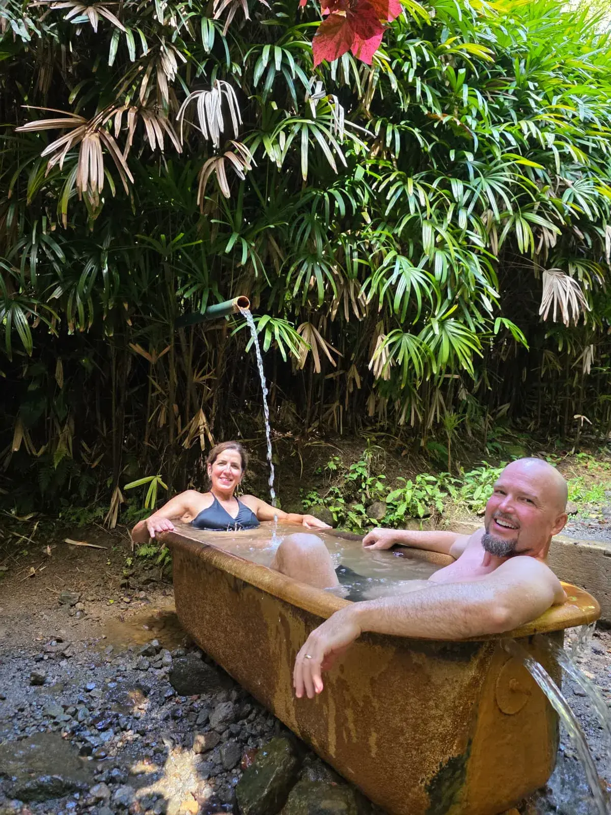 Guests relaxing in a natural stone hot-spring bath